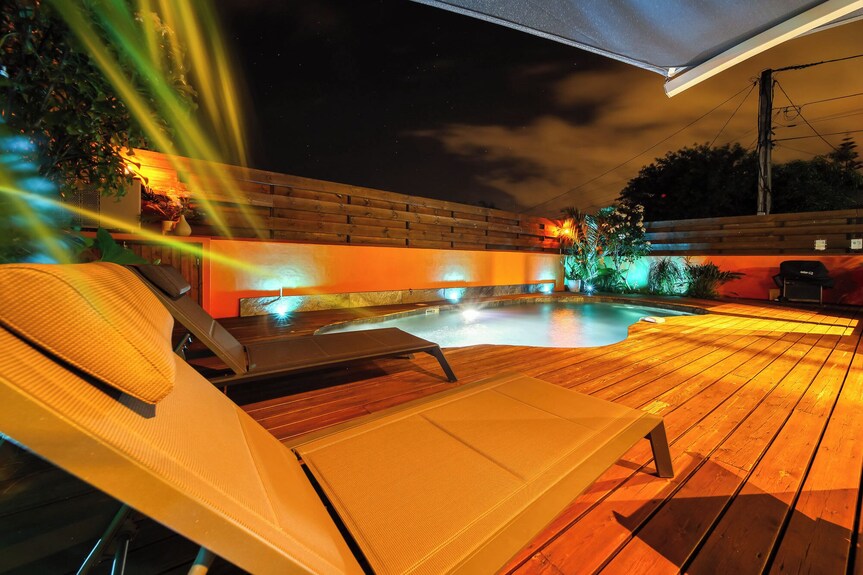Transats et piscine illuminés à la nuit tombée – villa avec piscine chauffée à Saint-Pierre, La Réunion