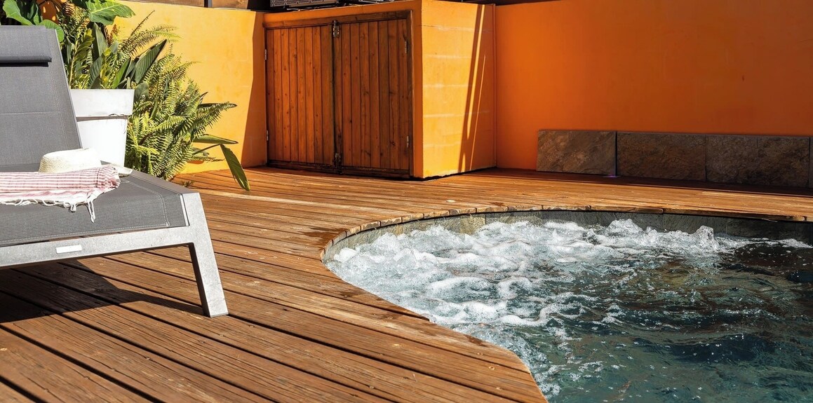 Bain à remous en pierre sur la terrasse en bois – villa avec piscine chauffée à Saint-Pierre, La Réunion
